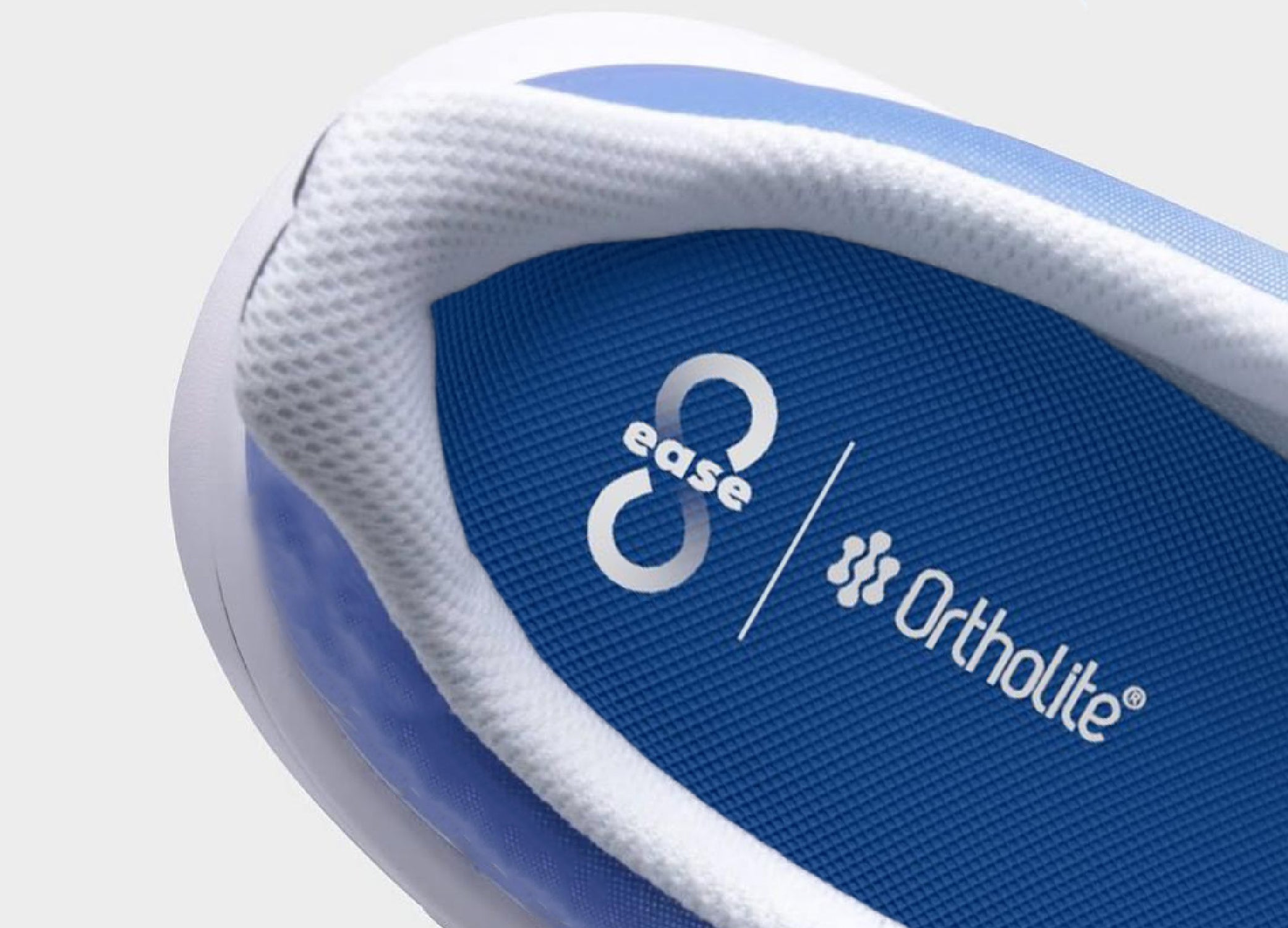Close-up of blue Ortholite insole branded with 8ease Daily Relief Arch Insoles, inside a white and blue shoe